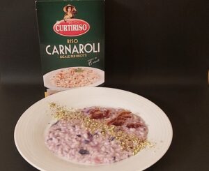 Impiattamento risotto in crema di cavolo viola aromatizzato all'aglio nero con gorgonzola piccante in mantecatura, pancetta piacentina e polvere di pistacchio_Carnaroli Curtiriso