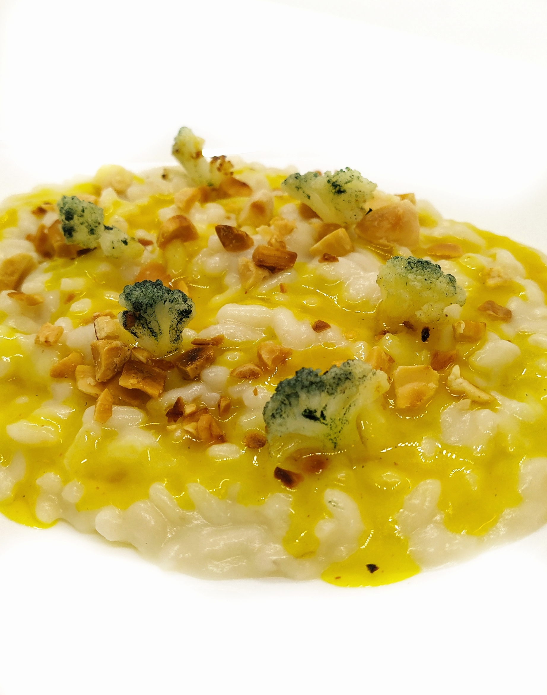 Risotto al cavolfiore con salsa allo zafferano, mandorle tostate e cavolfiore marinato al limone.