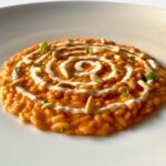 risotto al sugo con spirale di parmigiano, pinoli e basilico